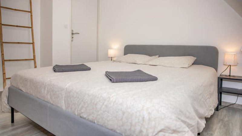 Chambre double avec grand lit 160 cm et tête de lit grise dans le gîte Mistral près de Saint-Malo