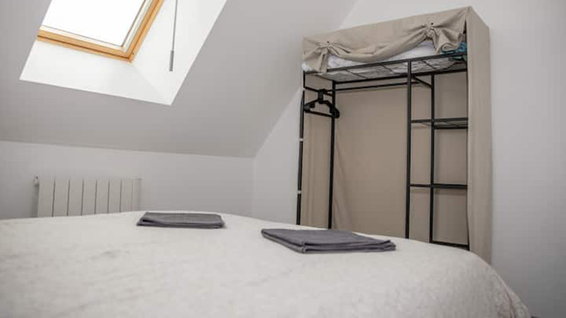 Chambre mansardée avec lit double, velux et dressing ouvert sous les toits du gîte Mistral Saint-Malo